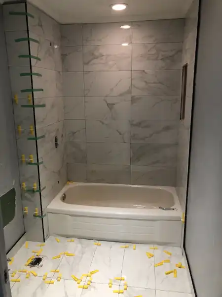 Grey stone-look tile shower installation in progress